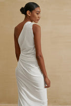 Back view of a model in a white one-shoulder draped dress