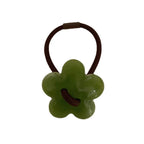 A single green flower-shaped hair tie with a brown elastic band.