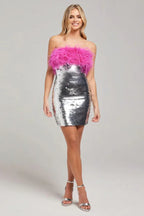 full body shot of a woman in a silver sequin dress with pink feather trim