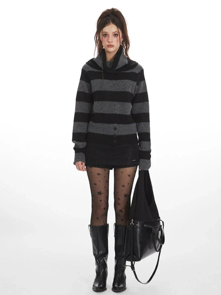 Model wearing a grey and black striped sweater with a turtleneck, black shorts, black tights with stars, and black boots, holding a black bag.