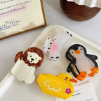 collection of animal hair claw clips including a cat, lion, penguin, and duck on a white tray