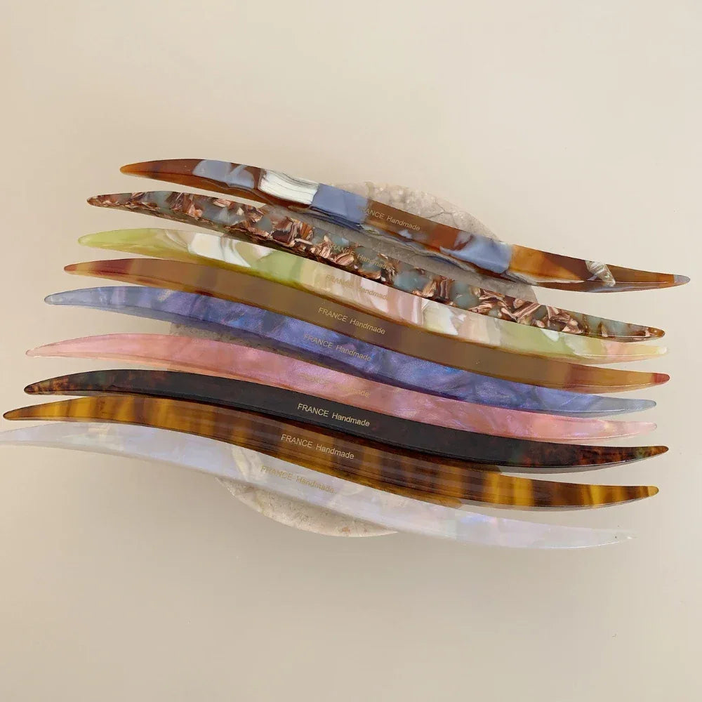 stack of curved marbled acetate hair pins with imprinted text