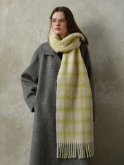 woman wearing a grey coat and a yellow plaid scarf
