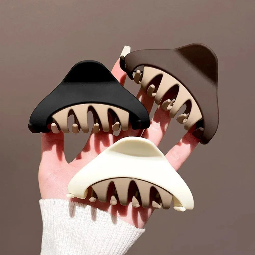 Three triangular hair claws in black, brown, and white