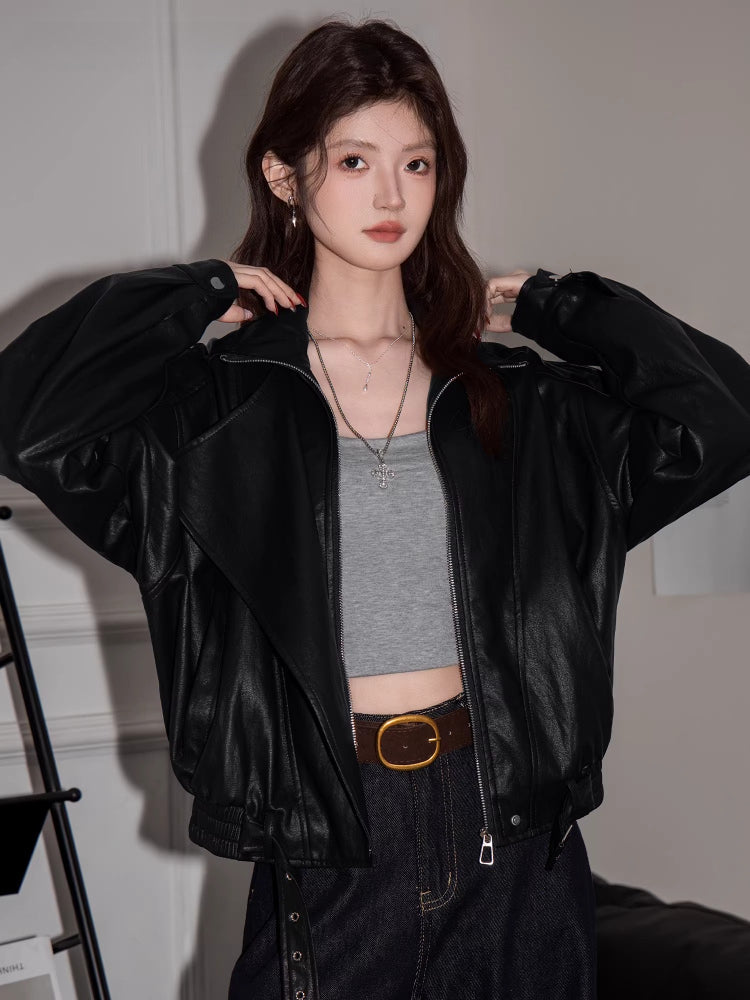 Close-up of a woman wearing a black faux leather jacket, showing the lapel collar and zipper detail.