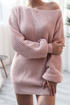 Woman with arms crossed wearing a pink off-the-shoulder ribbed knit tunic sweater.