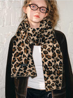 Model wearing a brown jacket with a leopard print scarf featuring a brand tag.