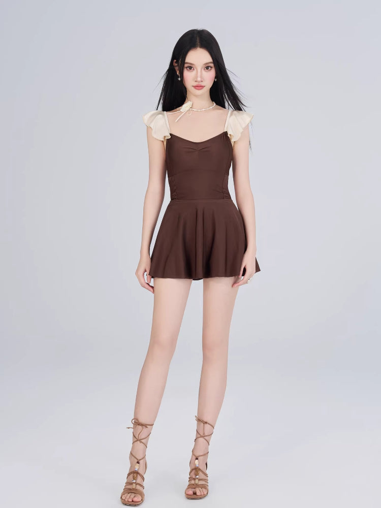 Woman wearing a brown and cream one-piece swimsuit with ruffled cap sleeves and a sweetheart neckline, shown full body from the front.