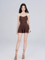 Woman wearing a brown and cream one-piece swimsuit with ruffled cap sleeves and a sweetheart neckline, shown full body from the front.