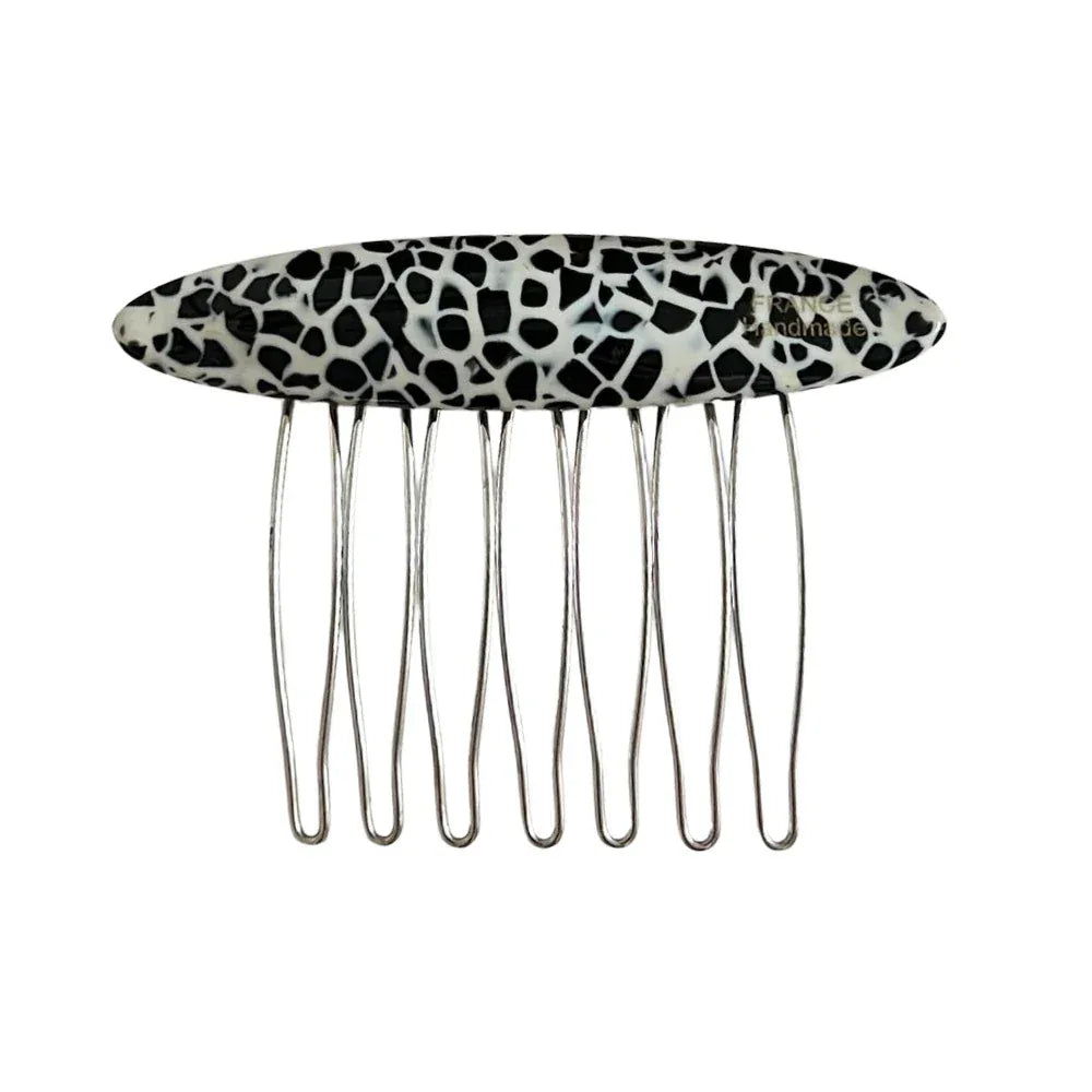 A black and white animal print hair comb with an oval decorative top and silver metal teeth, isolated on a white background.
