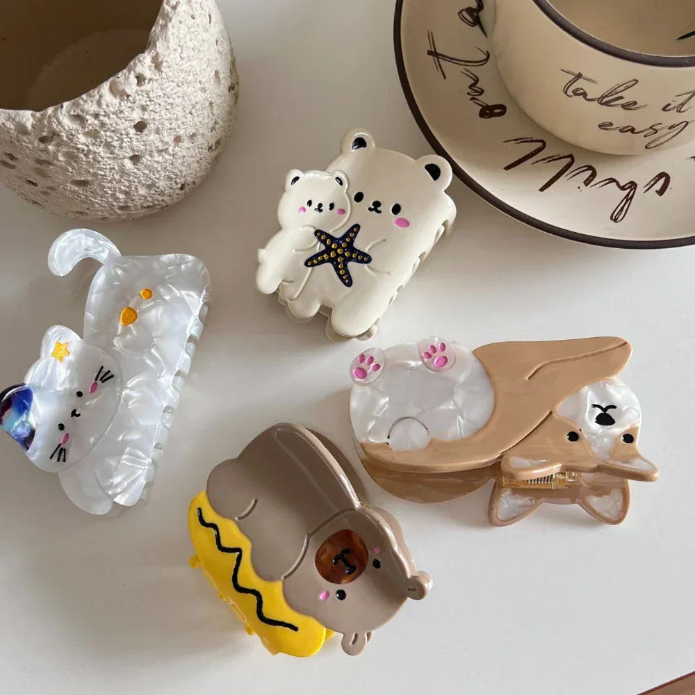 Collection of animal-themed hair claw clips including a corgi, bears, and a cat