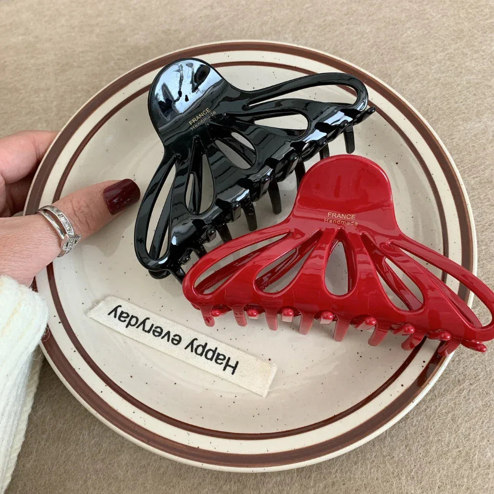 red and black octopus claw hair clips on a plate