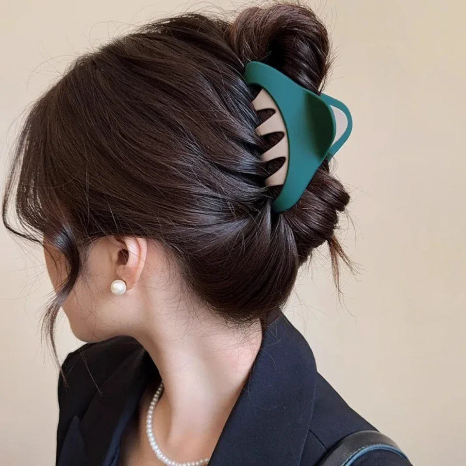 Woman with dark hair styled in a bun using a green and beige hair claw Secondary image