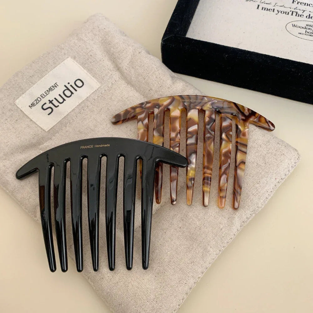 black and tortoise shell hair combs on a linen cloth