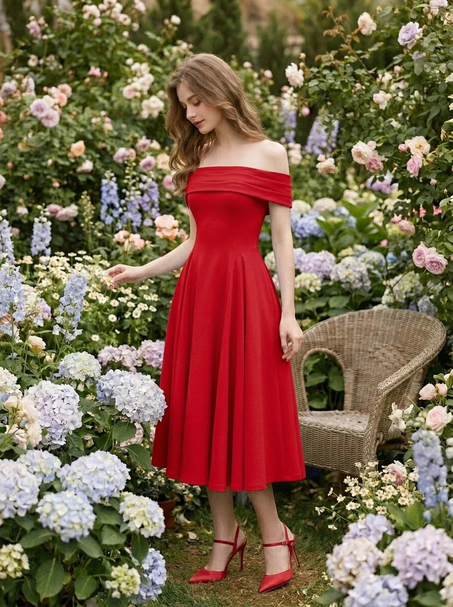 Woman wearing a red off-the-shoulder midi dress with flared skirt and red heels, standing in a garden with hydrangeas and roses.