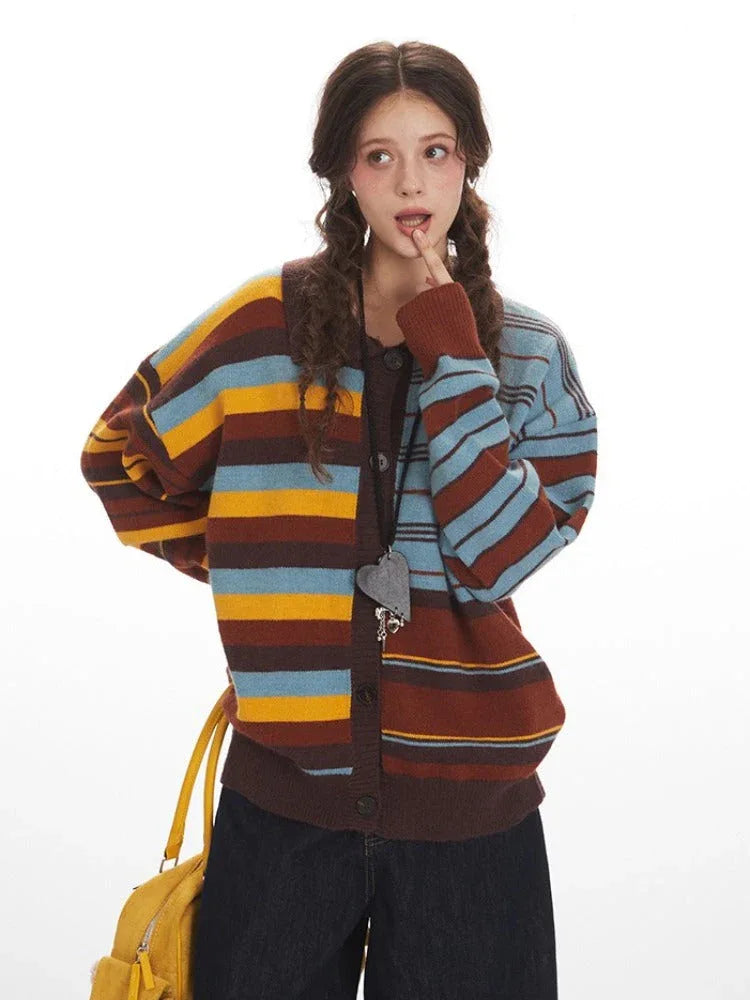 Close-up of a woman wearing a striped knit cardigan, resting her chin on her hand.