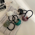 Collection of colorful resin ring hair ties on fabric