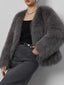 Woman wearing a grey faux fur cropped jacket with a black top and grey pants.