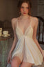 Woman wearing a cream-colored satin babydoll nightgown with lace accents.