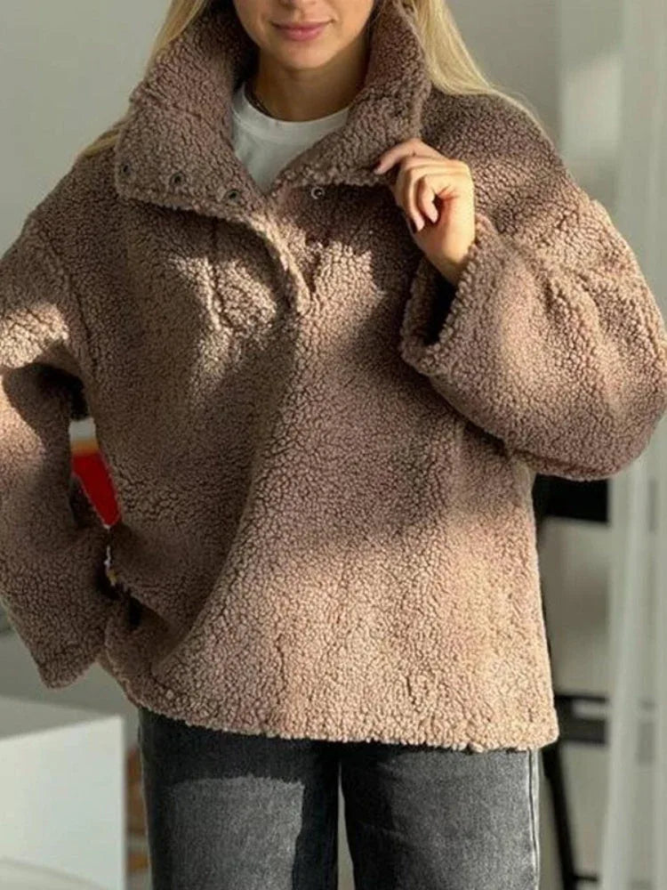 Detail of the button closure and collar on a brown fleece pullover.