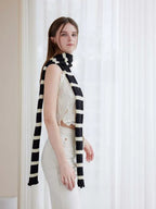 Side view of a woman wearing a black and white striped scarf