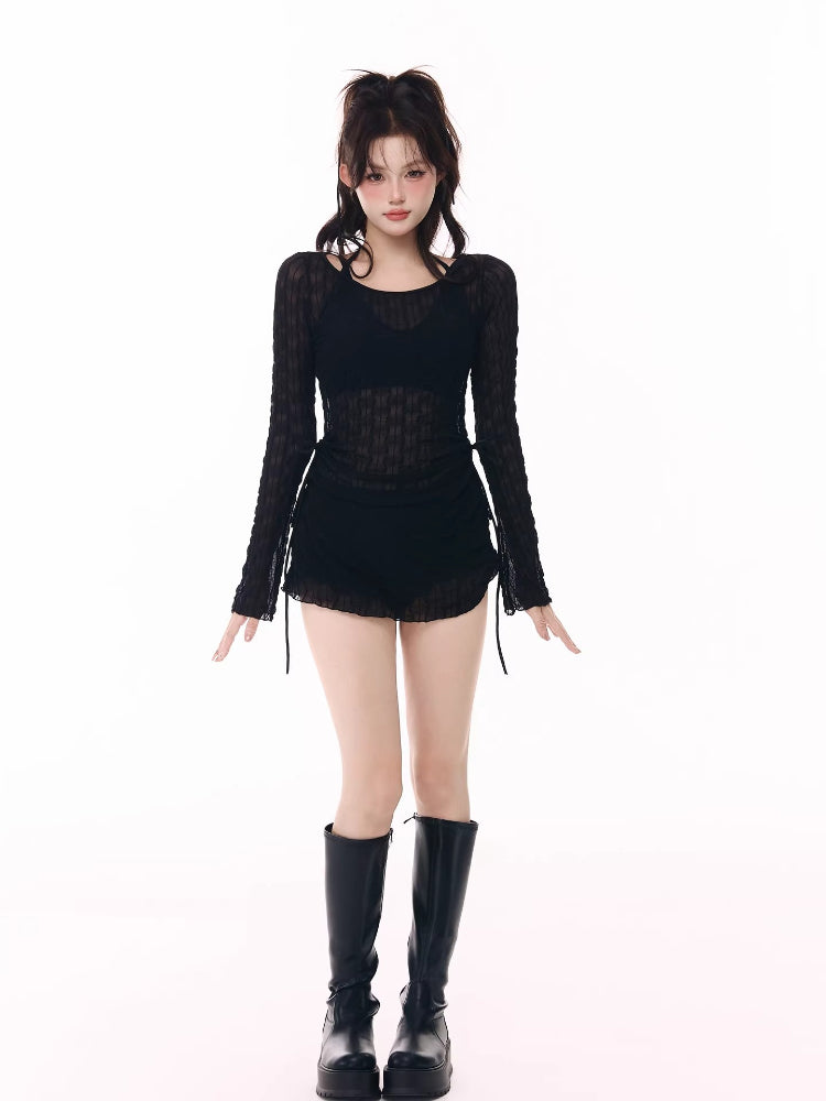 Model wearing a black sheer long-sleeve top, black shorts, and black platform boots.