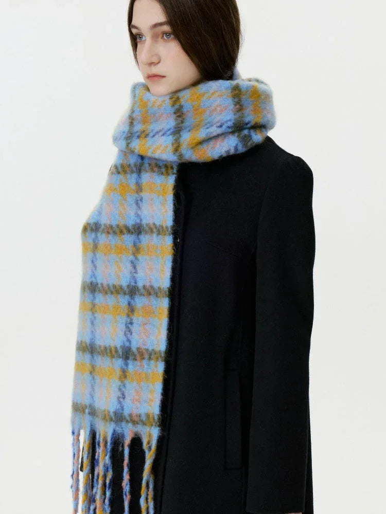 Woman wearing a black coat and a blue and yellow plaid scarf with fringe