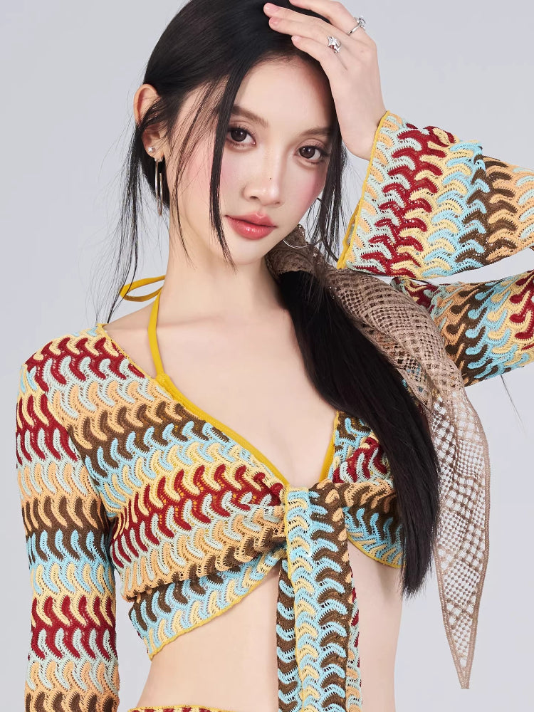Close-up of a woman's face and upper body wearing a crocheted knit top