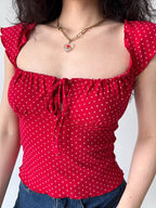 Close-up of the red off-the-shoulder top with a tie-front detail