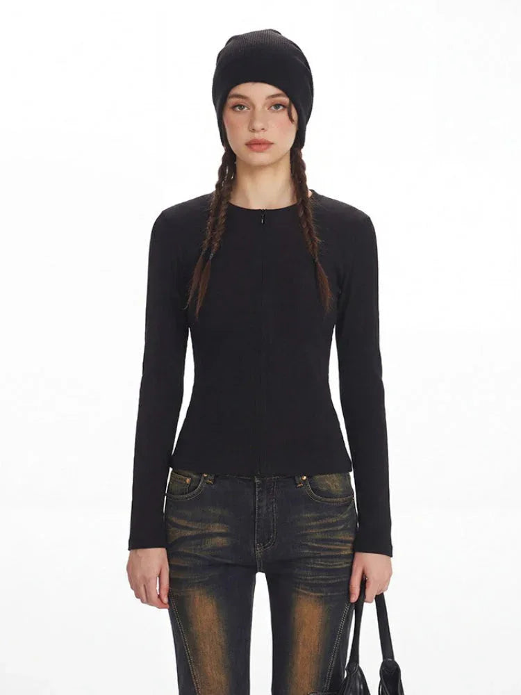 Close-up front view of a model wearing a black ribbed knit top and distressed flared jeans with fur trim cuffs.