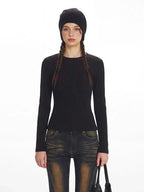 Close-up front view of a model wearing a black ribbed knit top and distressed flared jeans with fur trim cuffs.