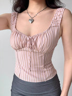 Woman wearing a pink striped ribbed knit top with a sweetheart neckline and tie front.