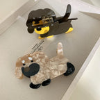 Top view of two dachshund hair claw clips, one brown and yellow, the other beige and black, in a tray