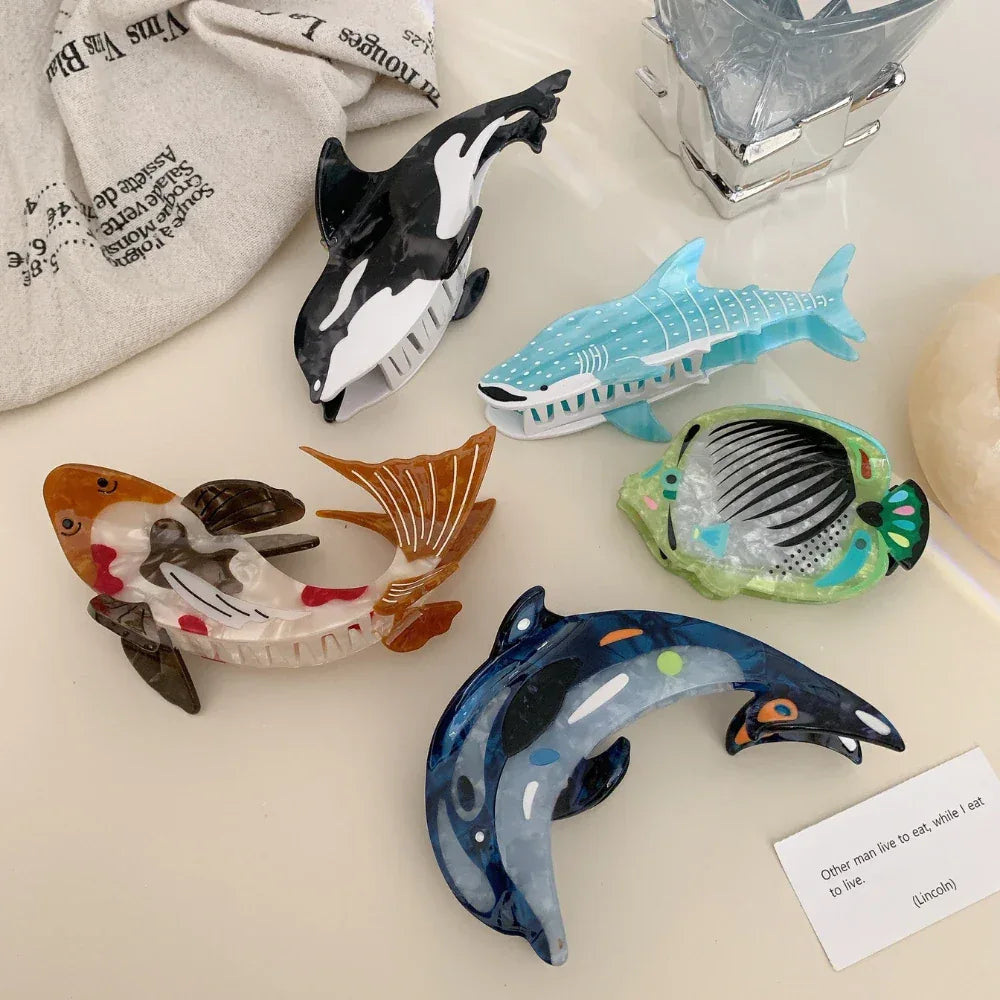 Collection of animal-shaped hair clips including a koi fish, orca, whale shark, dolphin, and angelfish