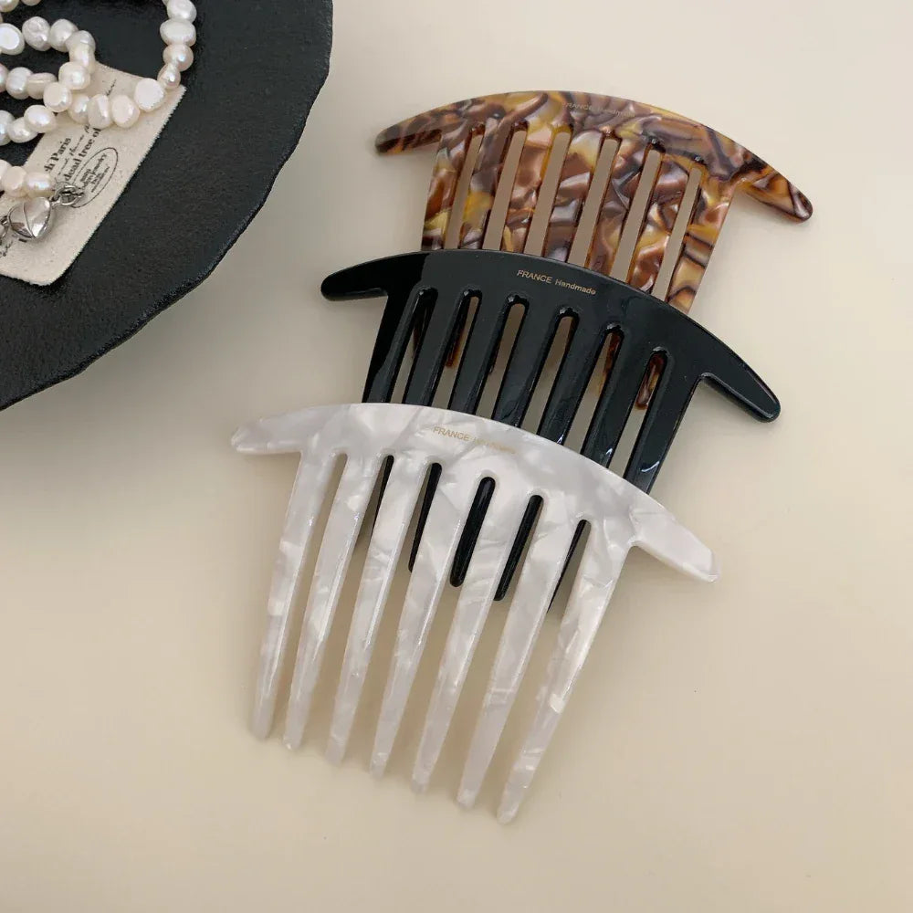 three hair combs in tortoise shell, black, and white marble patterns