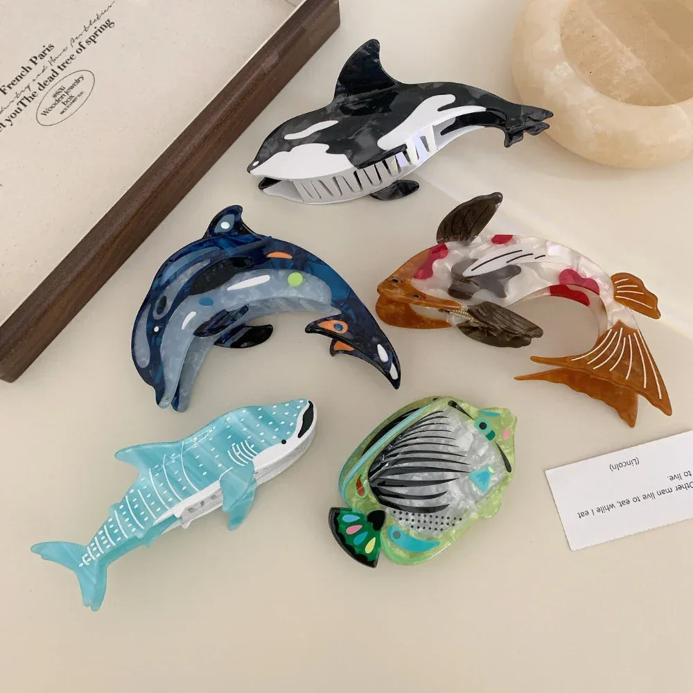 Assortment of animal-shaped hair clips including a koi fish, dolphin, orca, whale shark, and angelfish