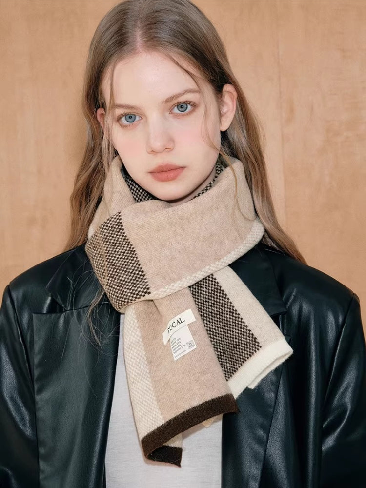 Young woman wearing a plaid knit scarf around her neck.