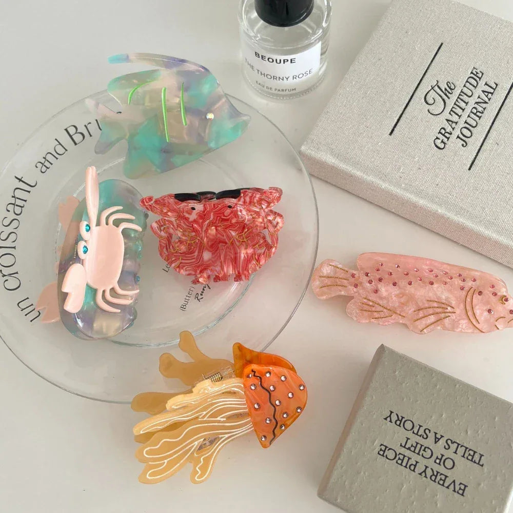 Collection of ocean-themed hair clips, including a jellyfish, crab, and fish, arranged on a plate