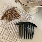 three French handmade hair combs arranged on a textured surface