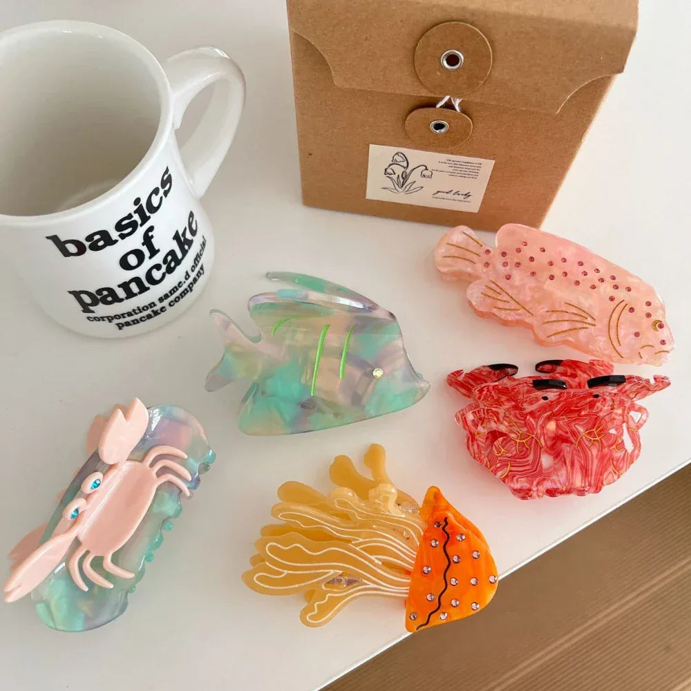 Assortment of colorful ocean-themed hair clips, including a jellyfish, crab, and fish, displayed with other items