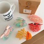 Assortment of colorful ocean-themed hair clips, including a jellyfish, crab, and fish, displayed with other items