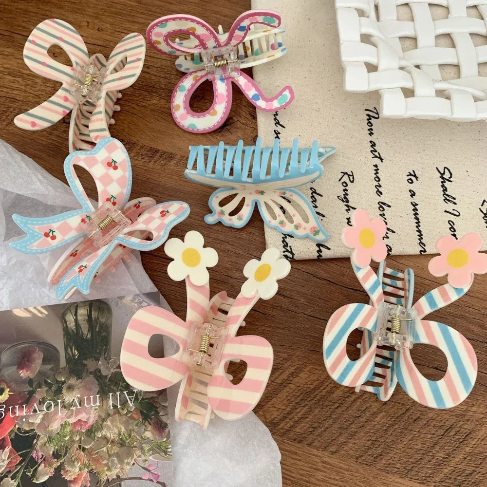 Close-up of pastel hair clips with bow and butterfly shapes, some adorned with stripes, cherries, and flowers