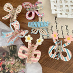 Close-up of pastel hair clips with bow and butterfly shapes, some adorned with stripes, cherries, and flowers