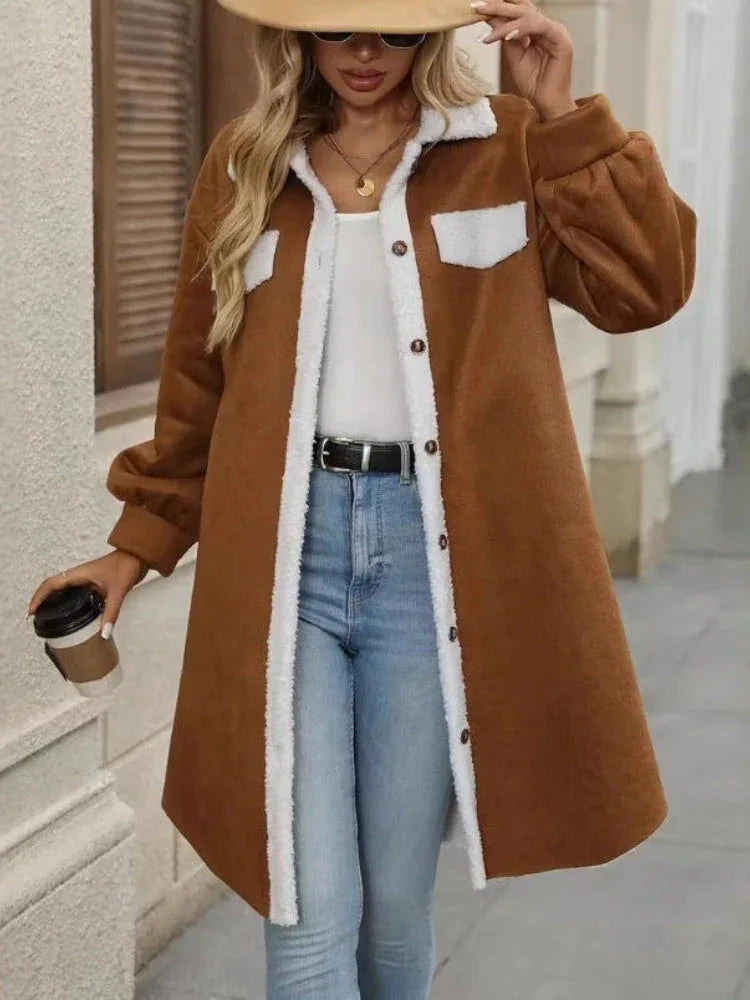 Woman wearing a brown fleece jacket with white sherpa trim and buttons, holding a coffee cup.