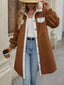 Woman wearing a brown fleece jacket with white sherpa trim and buttons, holding a coffee cup.