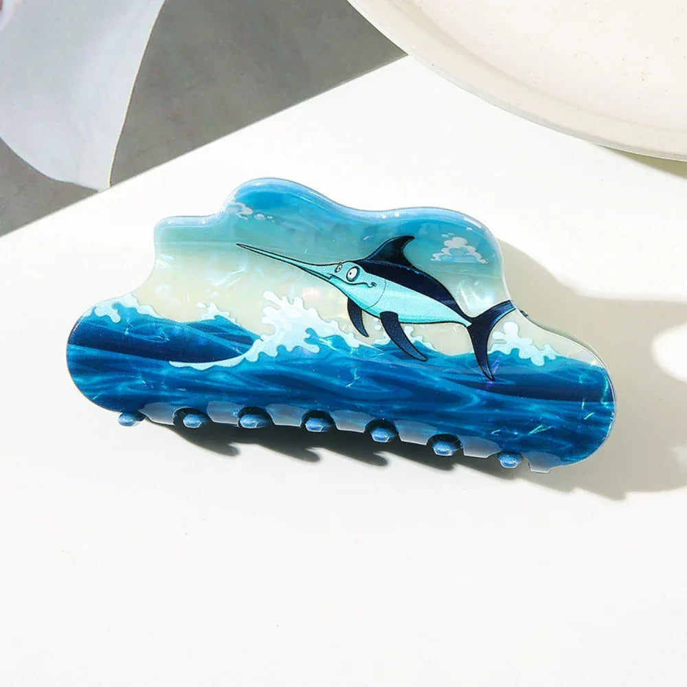 Close-up of a cloud-shaped hair claw with a swordfish in a dynamic ocean wave scene