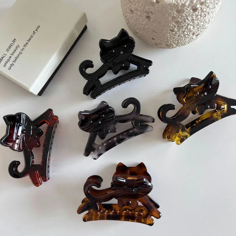 A variety of cat-shaped hair claw clips in different colors and patterns.