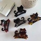 A variety of cat-shaped hair claw clips in different colors and patterns.