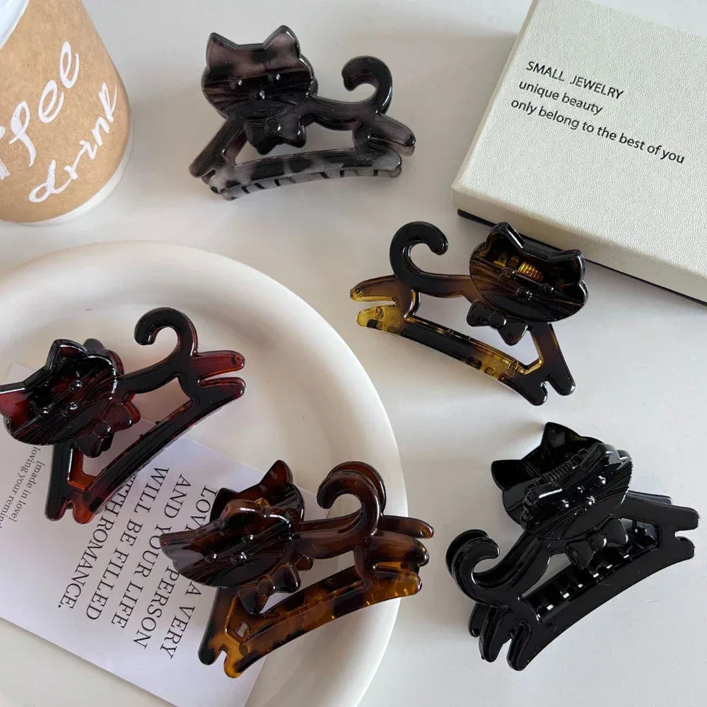 A group of cat-shaped hair claw clips displayed on a white table.