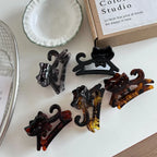 Several cat-shaped hair claw clips arranged on a white surface.